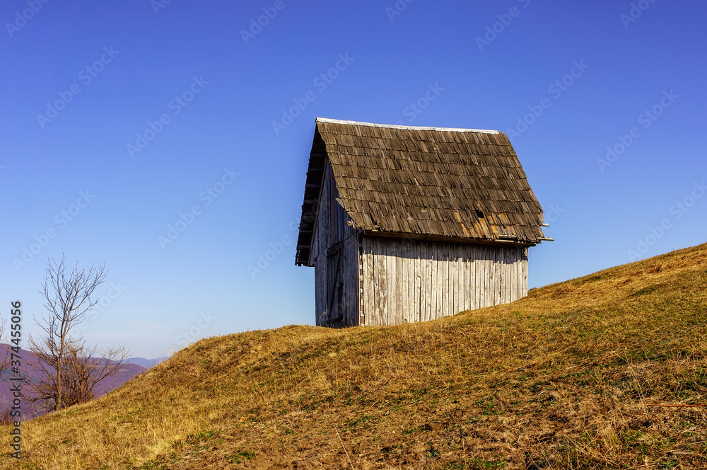 Small wooden house on a hillside in autumn