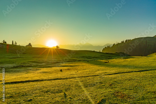 sunrise over the lush green mountains - clear sky and grass with dew - siri paye meadows © Safeer