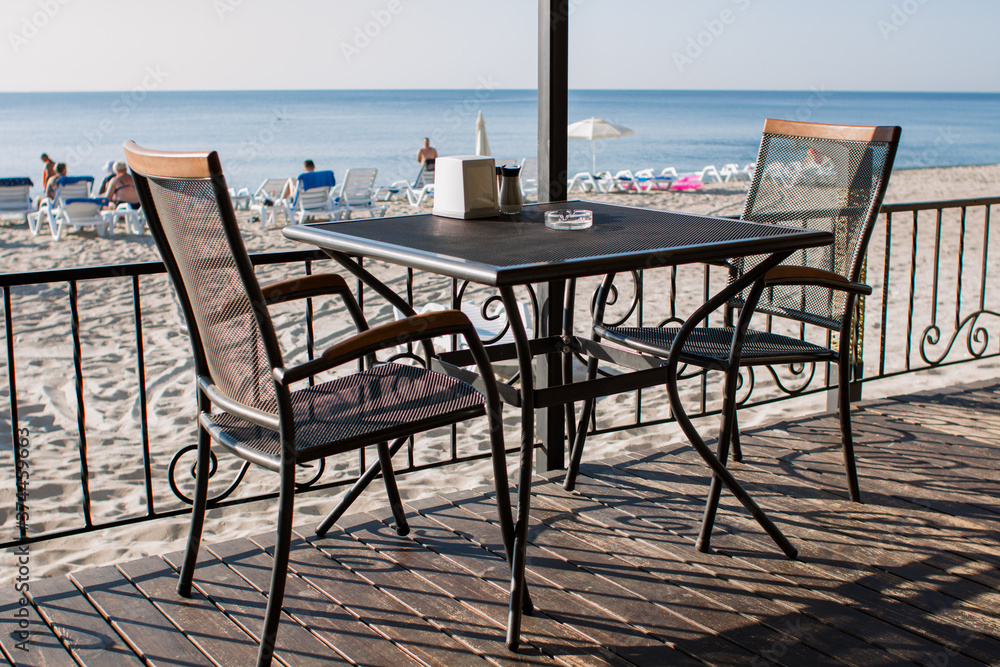 Fototapeta premium restaurant tables on the terrace near the beach