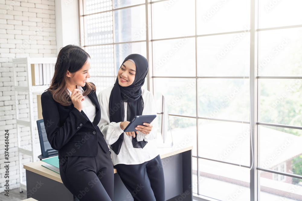 multiethnic asian female muslim workers working in office as team using tablet device to strategize and planning work concept of diversity of culture different race type of people co-working together multiethnic asian female muslim workers working in office as team using tablet device to strategize and planning work concept of diversity of culture different race type of people co-working together