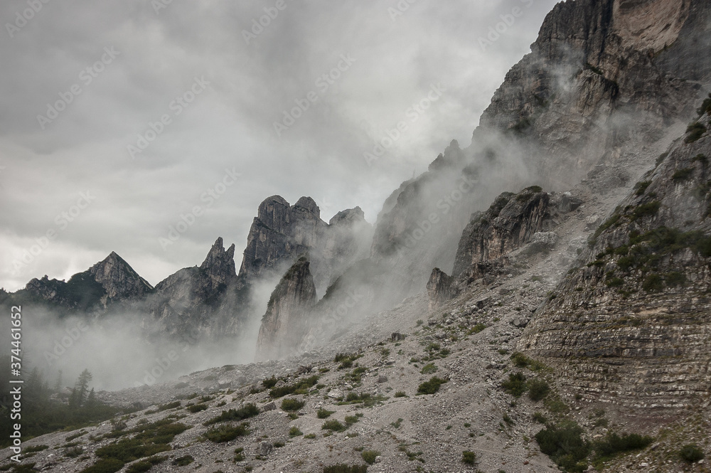 On trail #554 in dense fog before the last stretch to Rifugio Bruto Carestiato, beneath Pala del Belia mountain, Moiazza group, Alta Via 1 trek stage 10, Zoldo Dolomites, Belluno, South Tirol, Italy.