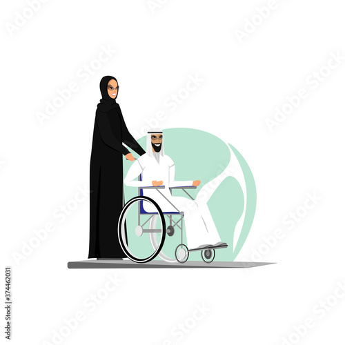  Arab woman carries a man in a wheelchair.