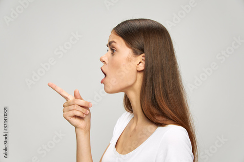 Woman in T-shirt shows thumb to the side side view Copy Space