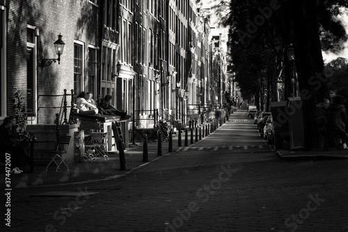 Amsterdam, Holland, the Netherlands - July 6 2020: capture of the typical Amsterdam scenery in black and white with canal, canalo house, clouds and the iconic buildings of the city © Antonie