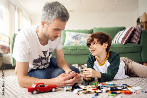Dad and son play toys and have fun together playing on the floor