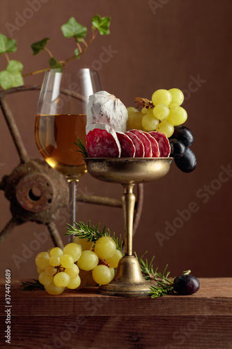 Glass of wine with snacks on a brown background.