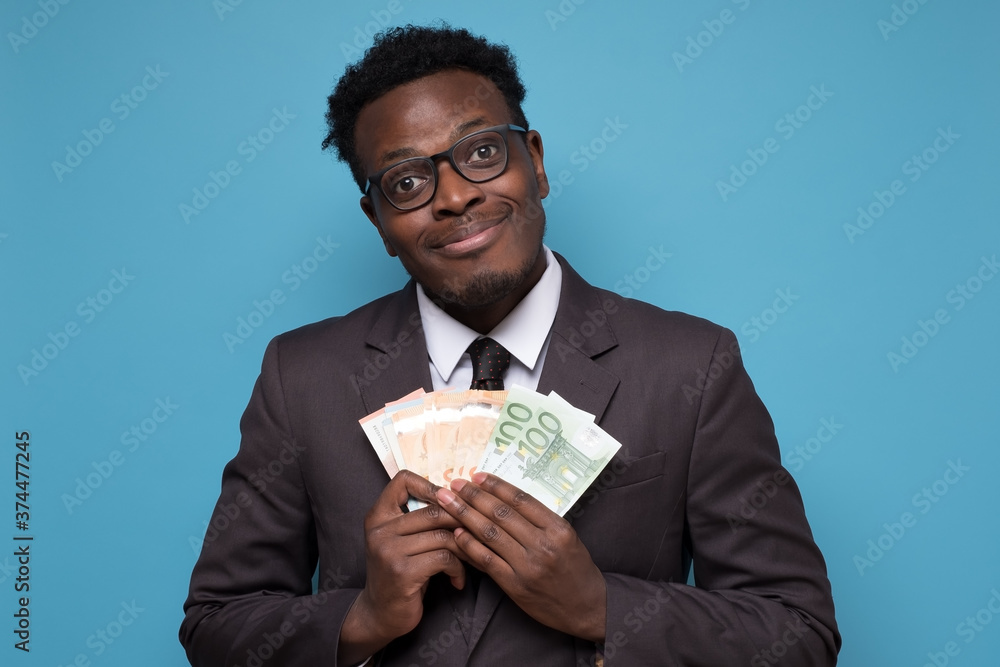 Successful young african businessman showing you money Successful young african businessman showing you money