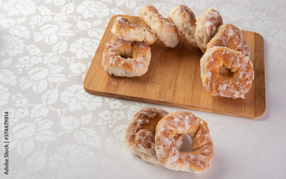 sugar-coated sweet cookies placed on a polished board on a table with white tablecloth, selective focus. sugar-coated sweet cookies placed on a polished board on a table with white tablecloth, selective focus.
