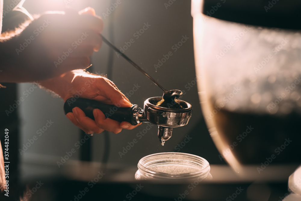 Fototapeta Adding coffee powder or green tea matcha powder in a port filter horn for a coffee machine.