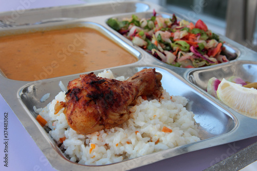 Chicken, rice and salad on a serving plate