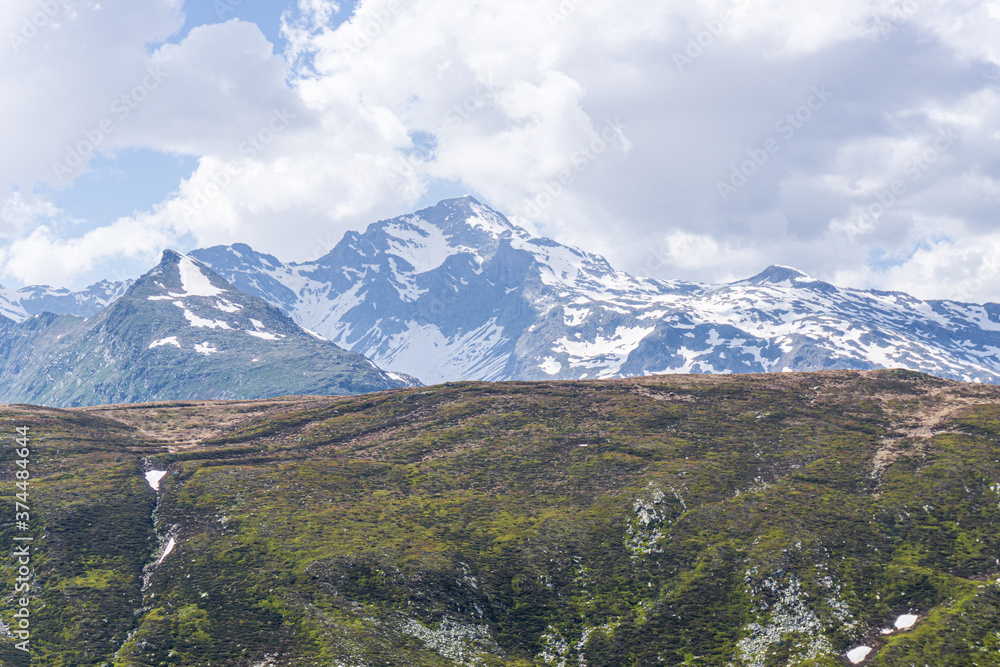 Obraz premium The snow-capped mountains of the Spluga valley during early summer, near the town of Madesimo, Italy - June 2020.