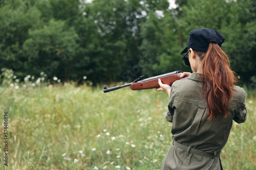 Woman on outdoor weapons in hand nature fresh air hunting green leaves 