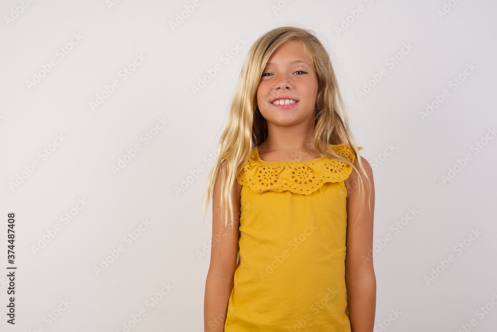 Φωτογραφία Young blonde kid girl wearing yellow dress over white background with a happy and cool smile on face