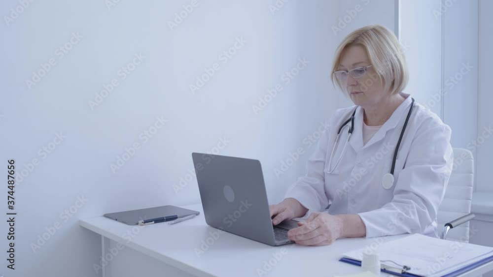 Clinic specialist typing on laptop in office, filling documents online, app Clinic specialist typing on laptop in office, filling documents online, app