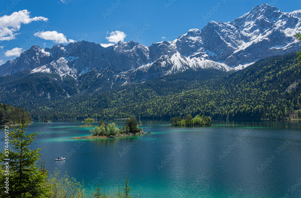 Naklejka premium Blick auf die noch leicht verschneite Zugspitze und den Eibsee im Sommer