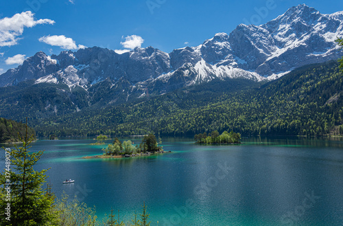 Blick auf die noch leicht verschneite Zugspitze und den Eibsee im Sommer