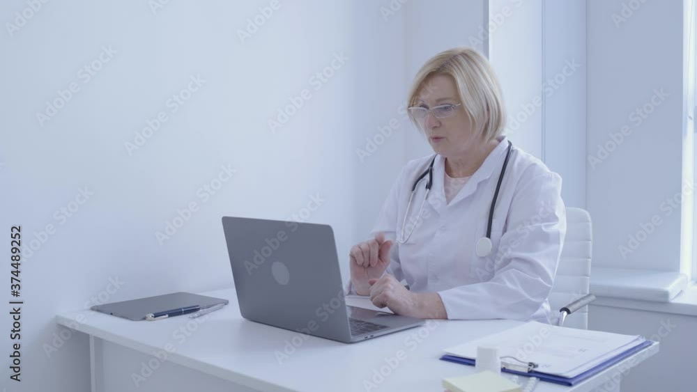 Female doctor talking to patient online by laptop app, remote consultation Female doctor talking to patient online by laptop app, remote consultation