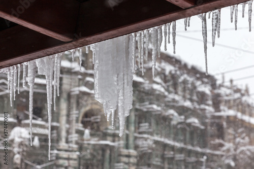 Winter landscape icicles hang from the roof. Icing. © Elena