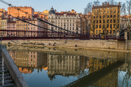 Bridge over the river in Lyon with building reflections on the water