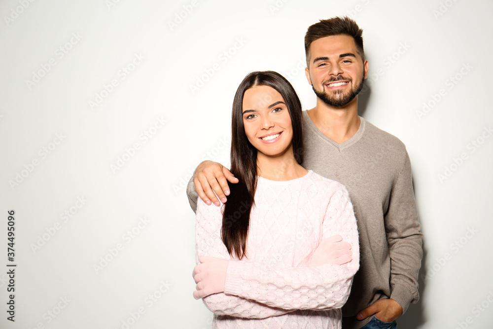 Lovely couple in warm sweaters on light background Lovely couple in warm sweaters on light background