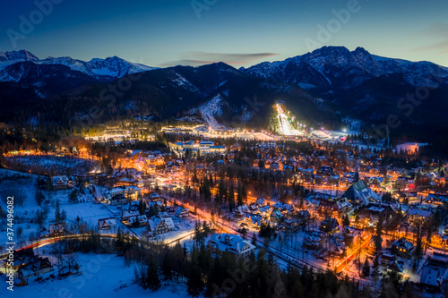 Stunning illuminated Zakopane city at night in winter, drone view