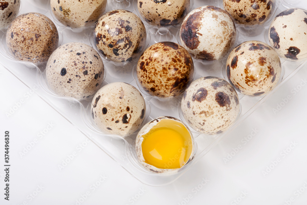 Fototapeta premium Eggs quail, broken egg in plastic container