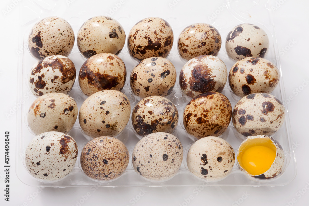 Eggs quail, broken egg in plastic container Eggs quail, broken egg in plastic container