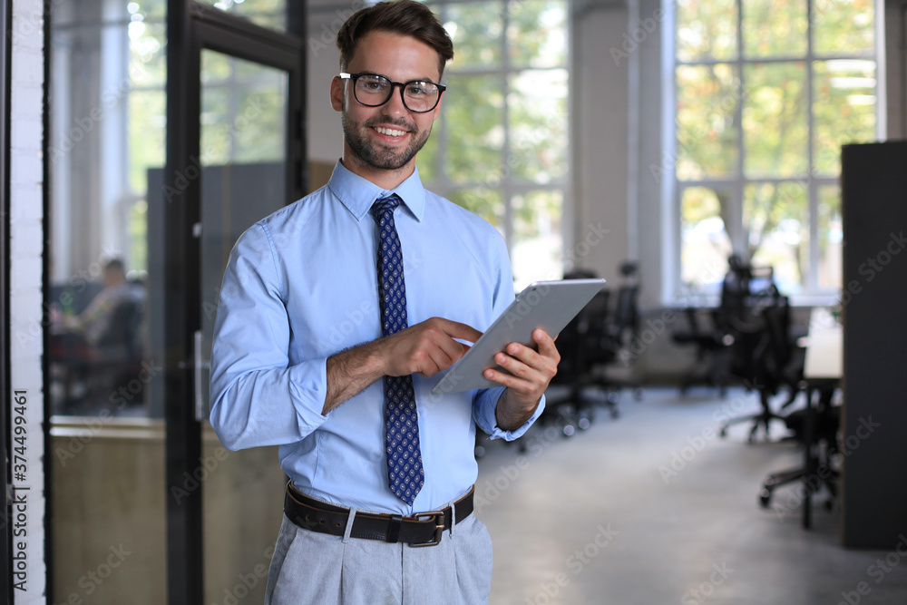 Fototapeta premium Young man using his tablet in the office.