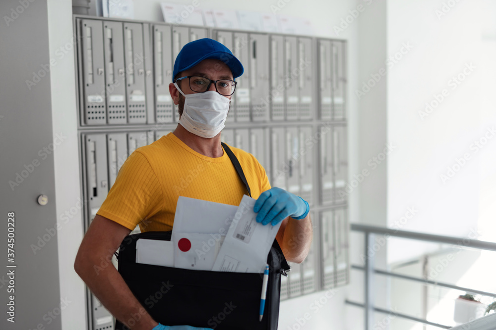 Mailman delivering mail with mail-bag and protective mask and gloves during virus pandemic. Mailman delivering mail with mail-bag and protective mask and gloves during virus pandemic.