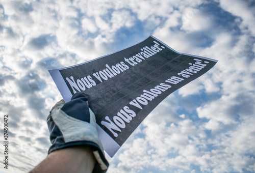 Economic crisis. Factory workers are losing their jobs. A worker holds a banner with the message 