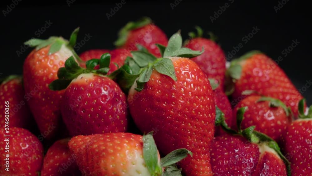 Bright Red Strawberries Piled on Black Background, Closeup Tilt Down Shot Bright Red Strawberries Piled on Black Background, Closeup Tilt Down Shot
