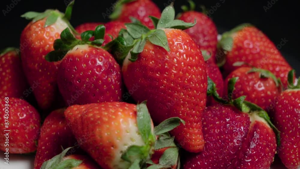 Tilt Up of Strawberries Piled with Black Background, Closeup Tilt Up of Strawberries Piled with Black Background, Closeup