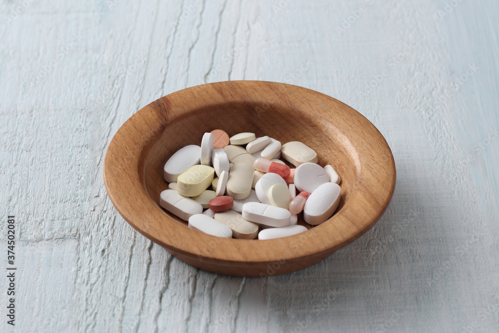 tablets and capsule in a wooden bowl. tablets and capsule in a wooden bowl.