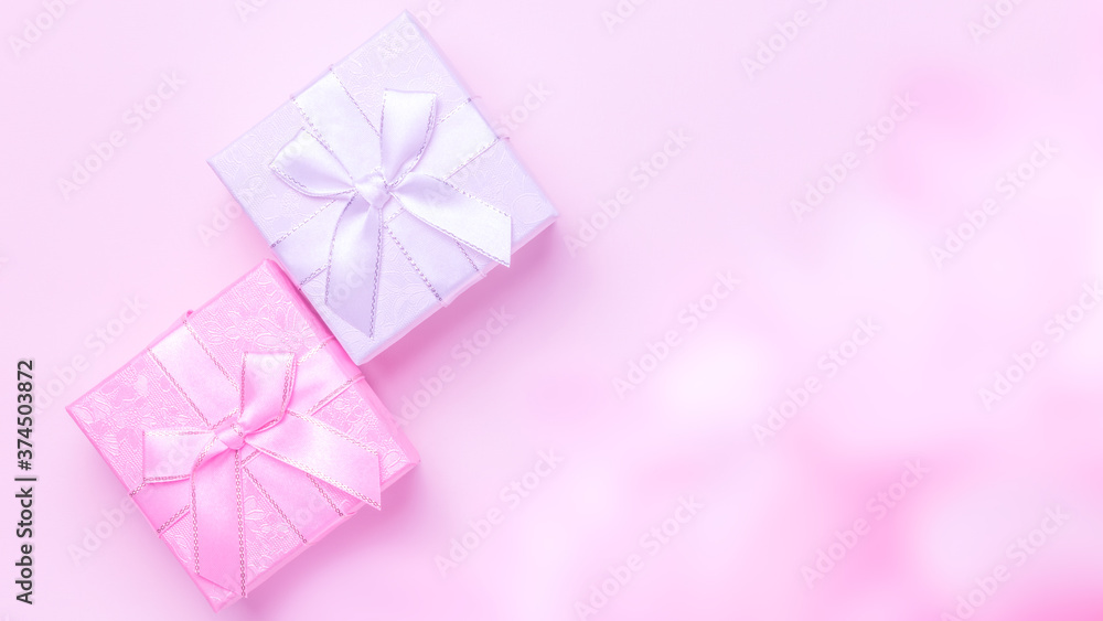 Beauty. Festive greeting banner poster for advertising or postcard, gift wrapping, silver box with a bow of ribbons in the haze for holiday on a pink background with raspberry smoke top view flatlay