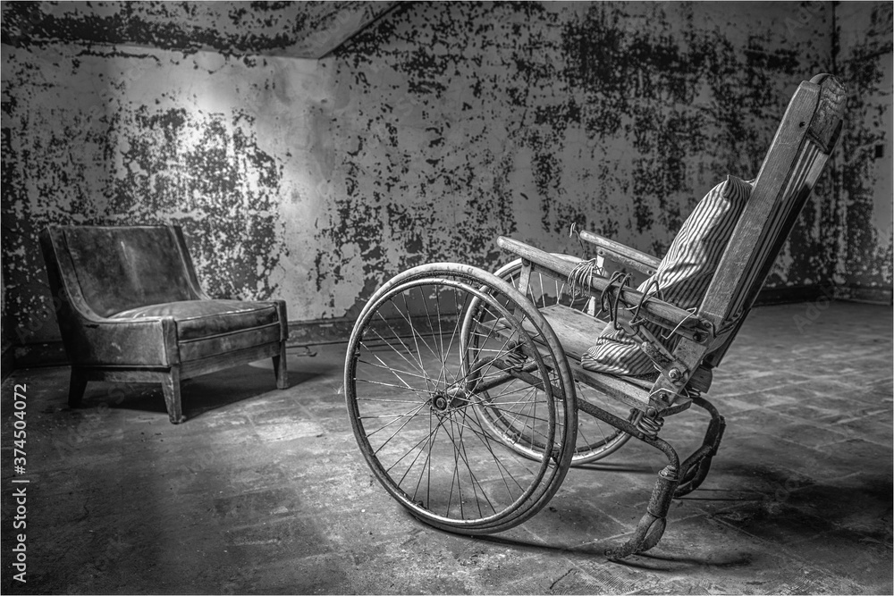 Antique wheelchair in an abandoned mental institution, in black and white