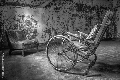 Принти на полотні Antique wheelchair in an abandoned mental institution, in black and white