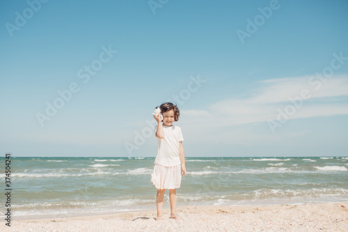 Curly young toddler girl with seashell © sweetlaniko