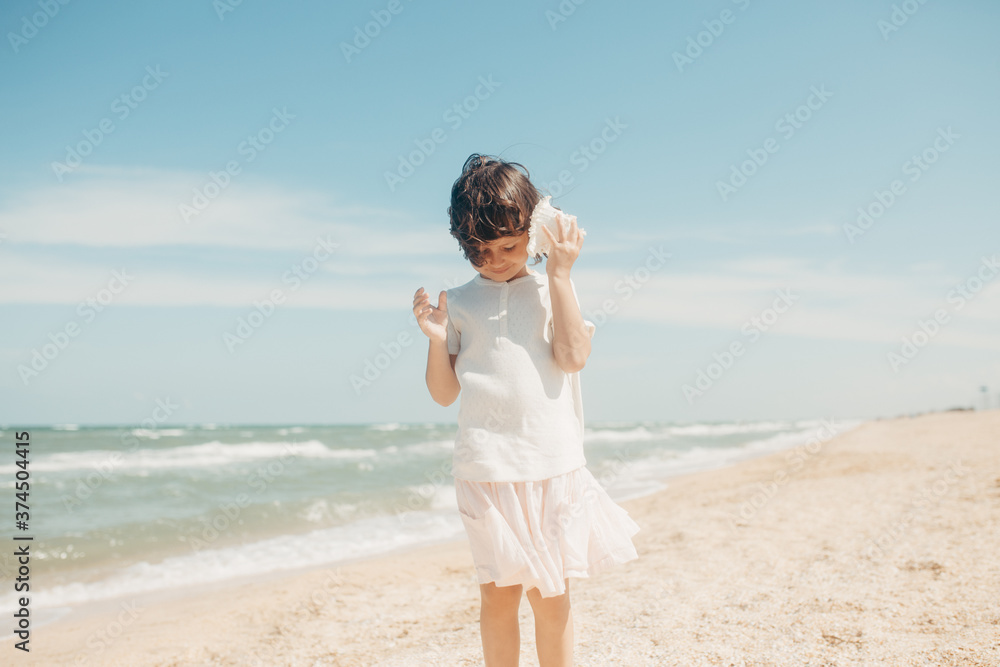 Curly young toddler girl with seashell Curly young toddler girl with seashell