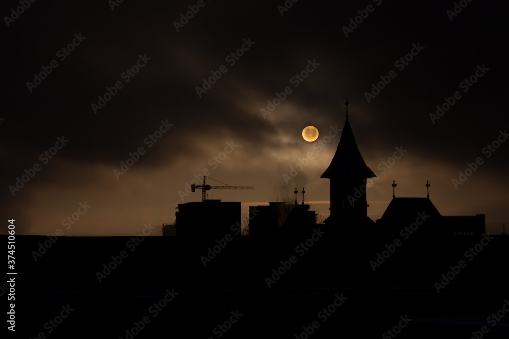 Fade sunrise with fog and dark sky with silhouette church and buildings construction