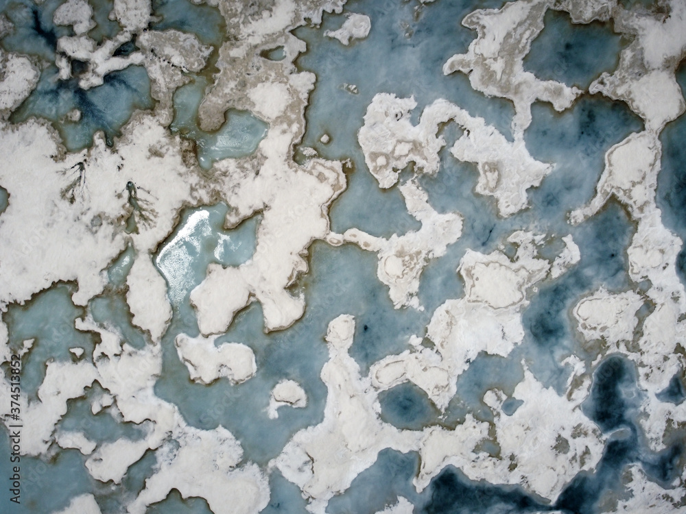 Stunning Aerial Drone view of frozen lake. Drone shot of a lake covered with pieces of melting ice during the spring
