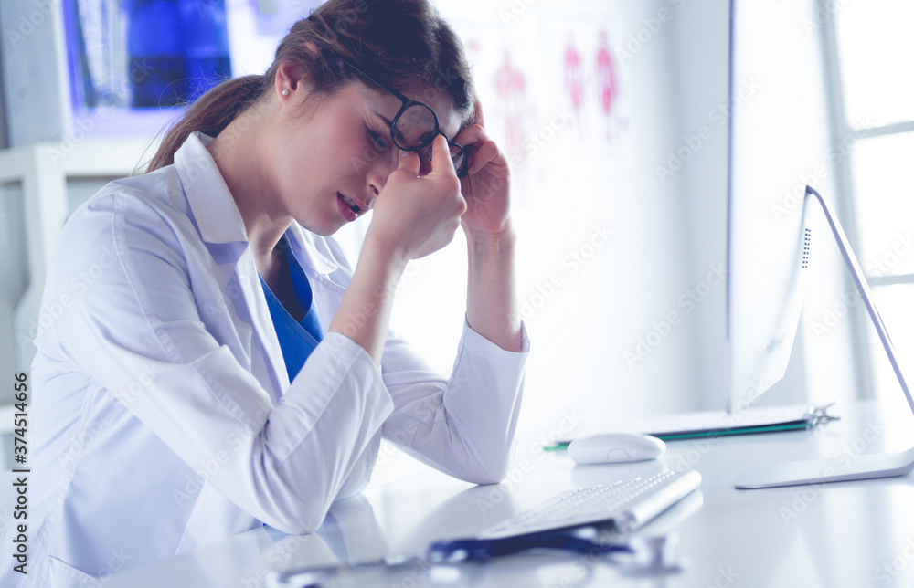 Portrait of a young female doctor suffering from a headache at work Portrait of a young female doctor suffering from a headache at work