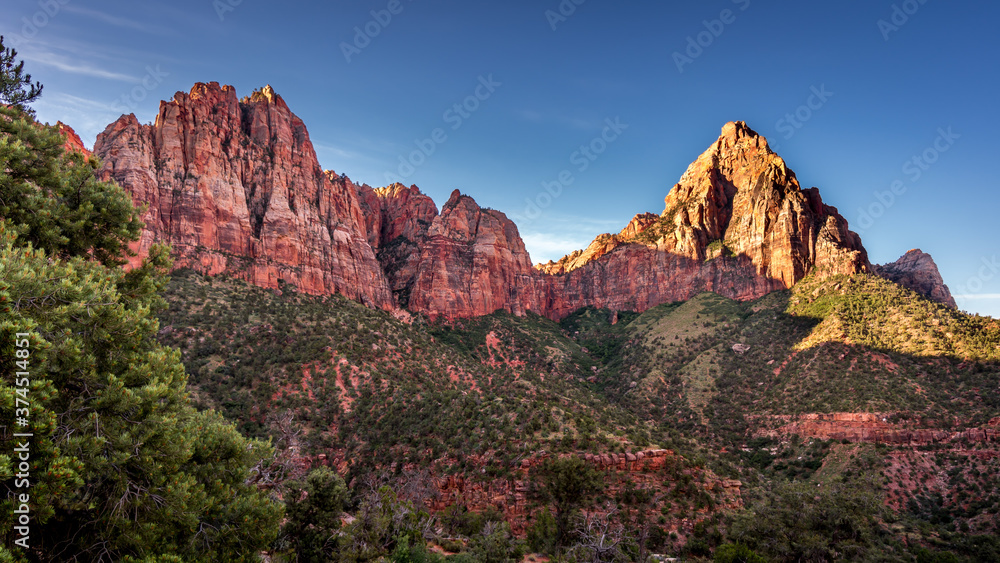 Sunrise over The Watchman Peak and Bridge Mountain and Red Sandstone Cliffs in Zion National Park in Utah, USA, during an early morning hike on the Watchman hiking trail