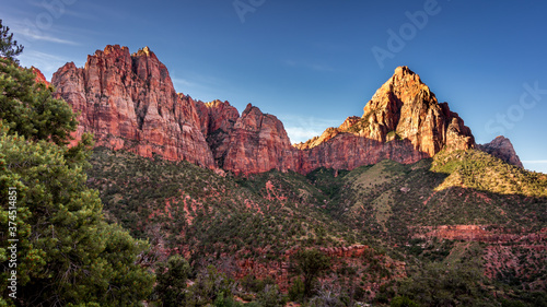 Sunrise over The Watchman Peak and Bridge Mountain and Red Sandstone Cliffs in Zion National Park in Utah, USA, during an early morning hike on the Watchman hiking trail
