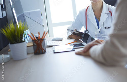 A doctor is talking and examining a patient
