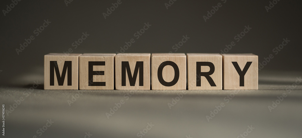 Memory word written with wooden blocks on gray baskground.