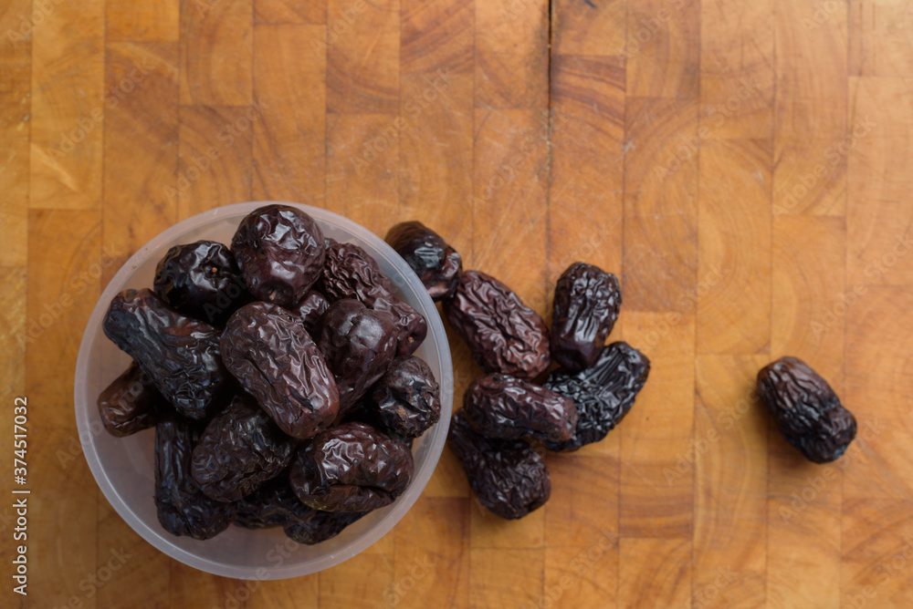 Pile of dried date palm isolated on wooden cutting board Pile of dried date palm isolated on wooden cutting board