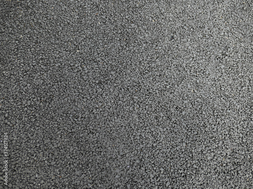 A smooth dark grey asphalt pavement texture with small rocks