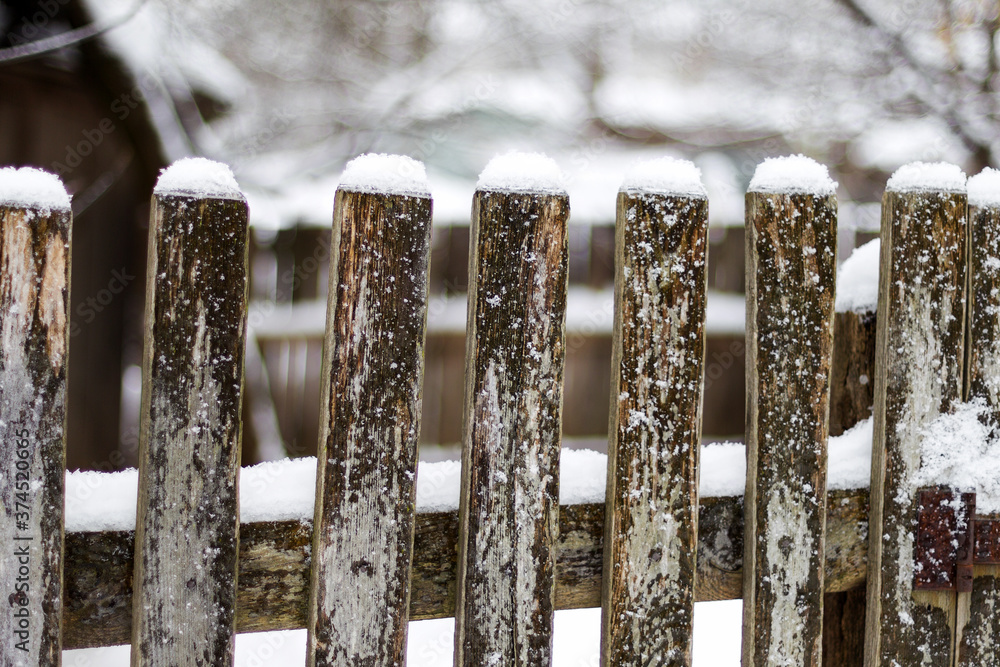 Texture of weathered wooden wall. Falling snow, in winter. Aged wooden plank fence of vertical flat boards Texture of weathered wooden wall. Falling snow, in winter. Aged wooden plank fence of vertical flat boards