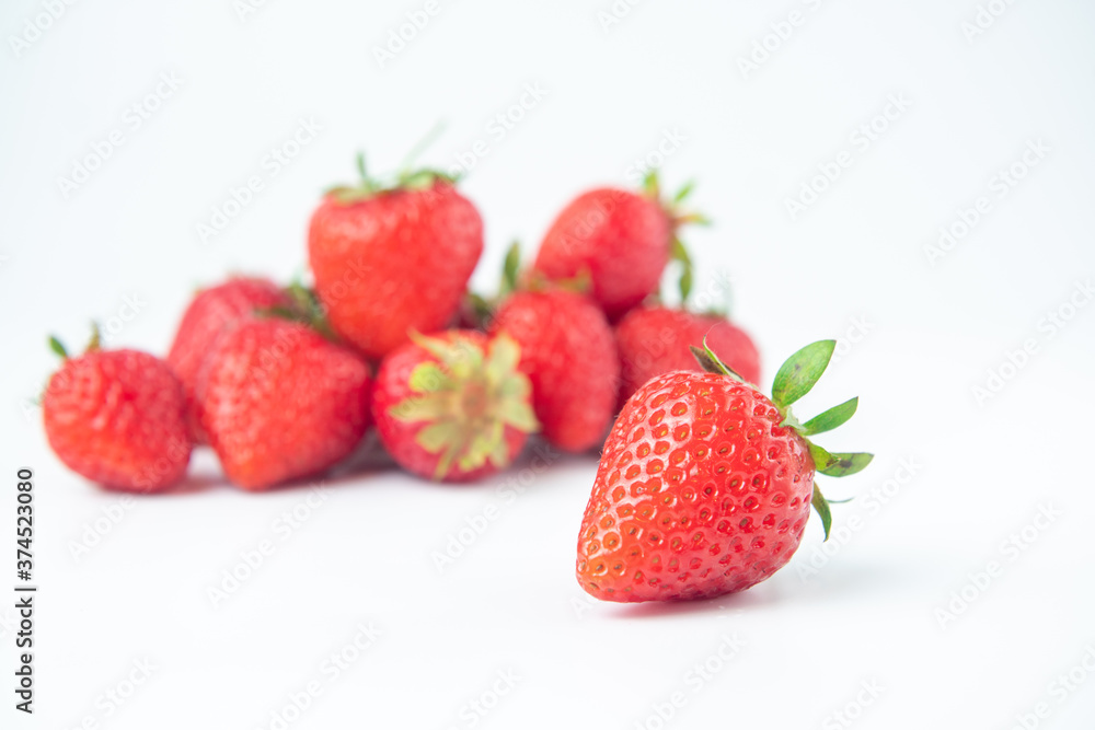 several strawberries are removed from the glare on a white background