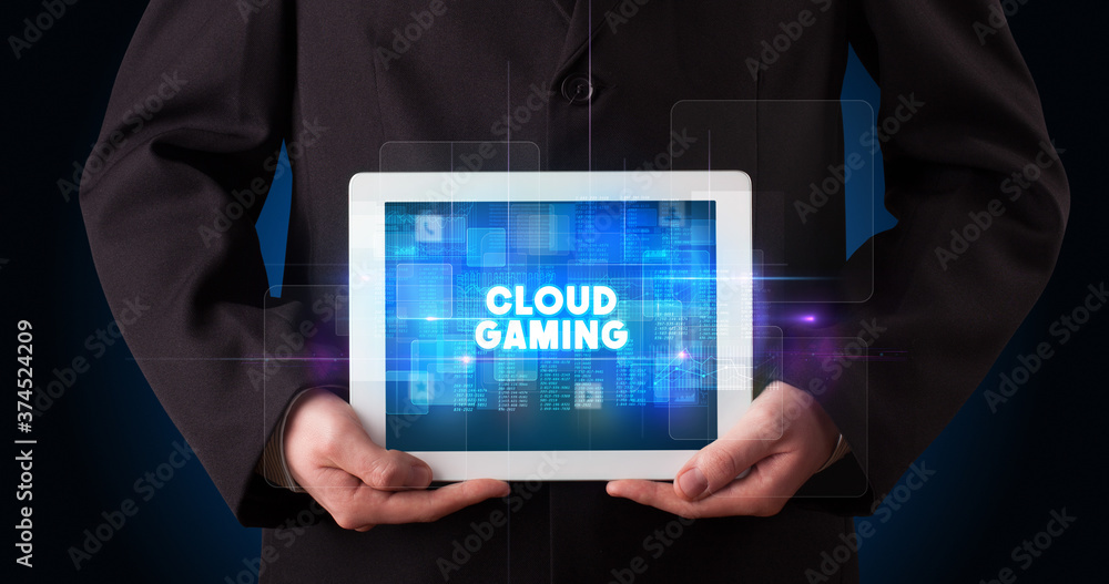 Young business person working on tablet and shows the inscription: CLOUD GAMING Young business person working on tablet and shows the inscription: CLOUD GAMING
